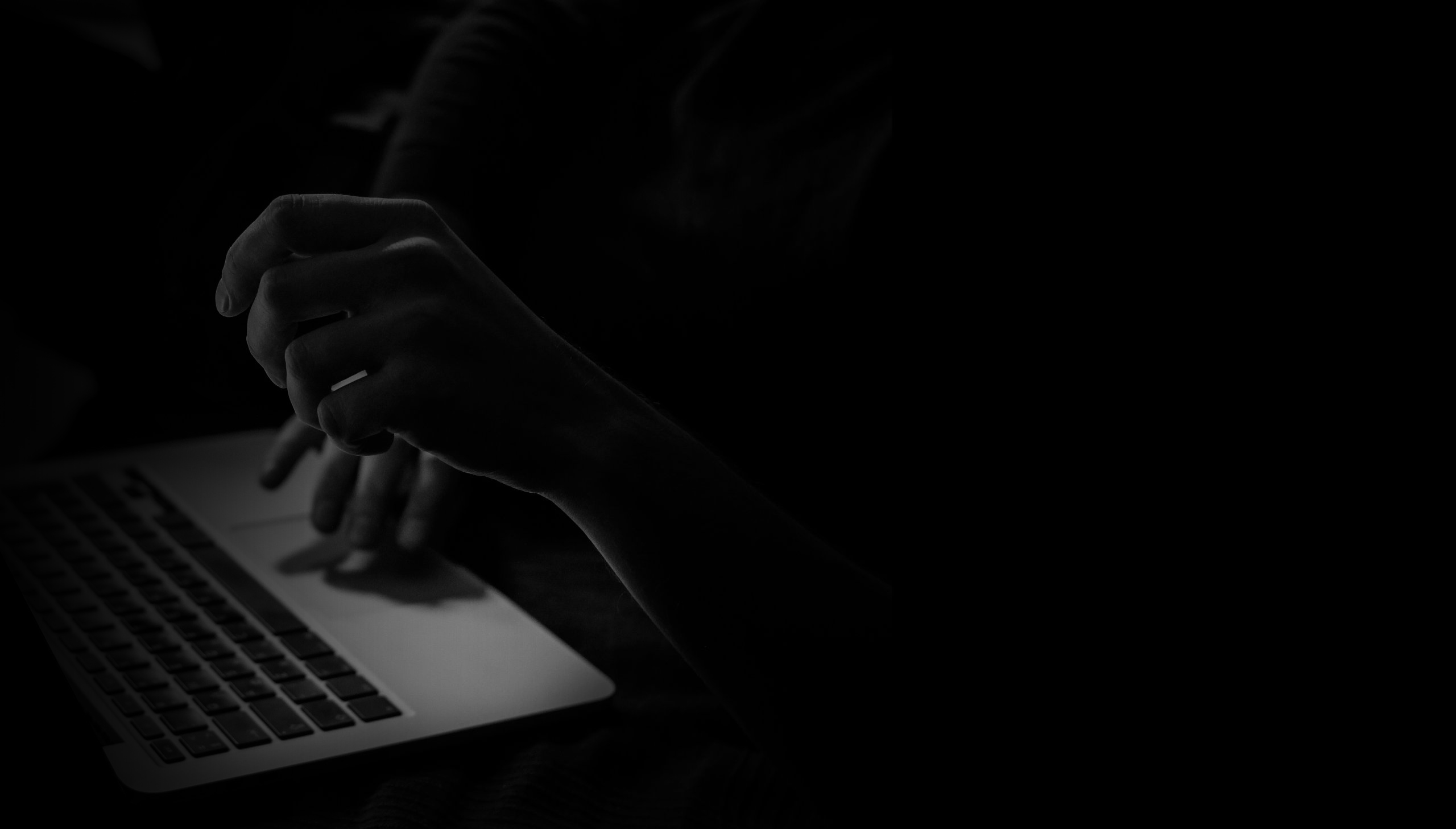 Angeschnittenes Notebook mit Händen davor in schwarz-weiß. Kommunikationsdesign Ulrike Schwier.